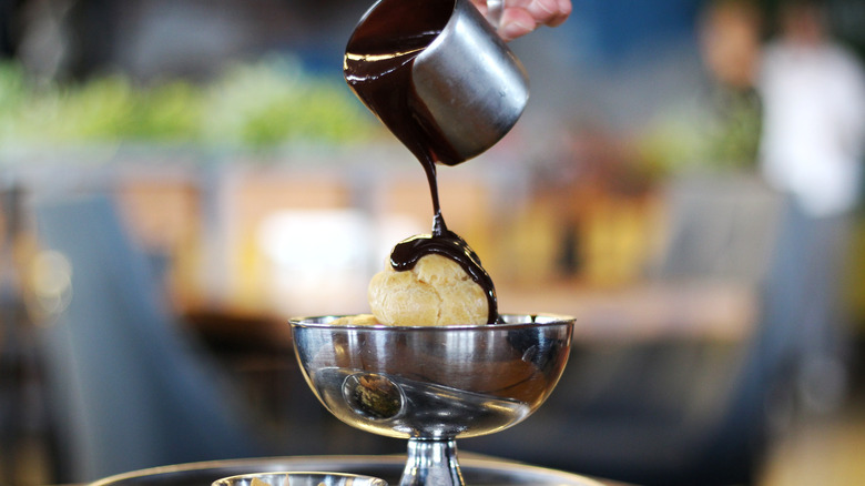 Chocolate sauce poured over a bowl of ice cream