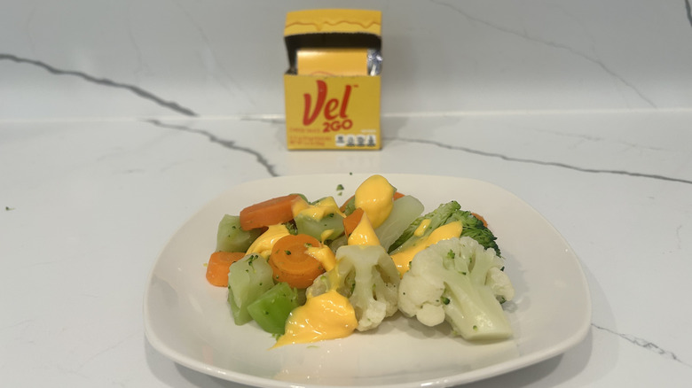 Steamed vegetables like carrots, broccoli, cauliflower are covered in Velveeta cheese