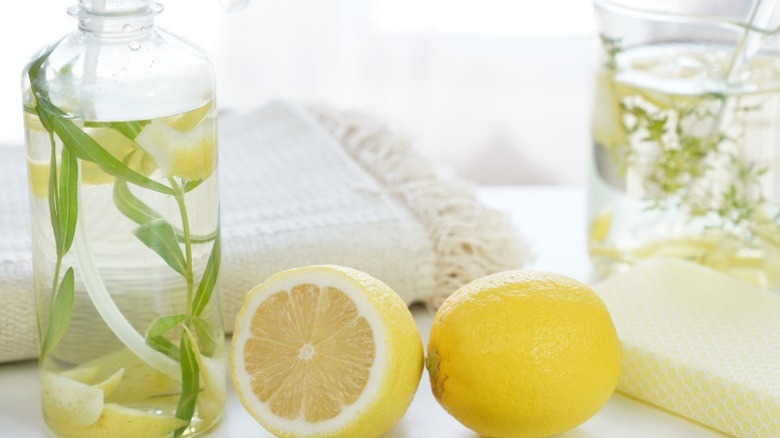 Lemons with spritzer bottle of lemon cleaner and a towel.