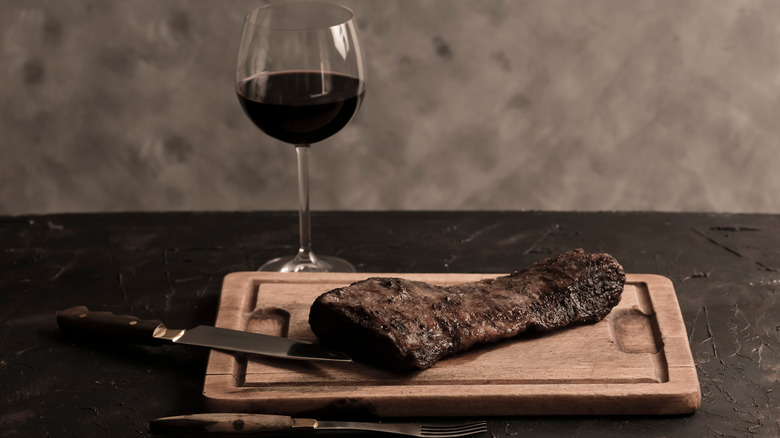 Steak on a cutting board with glass of Malbec wine