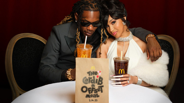 Music artists Cardi B and Offset are shown sitting at a table with drinks and a McDonald's meal