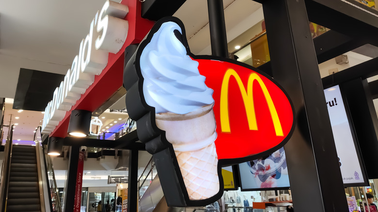 A sign featuring the mcdonald's logo next to a soft serve ice cream cone