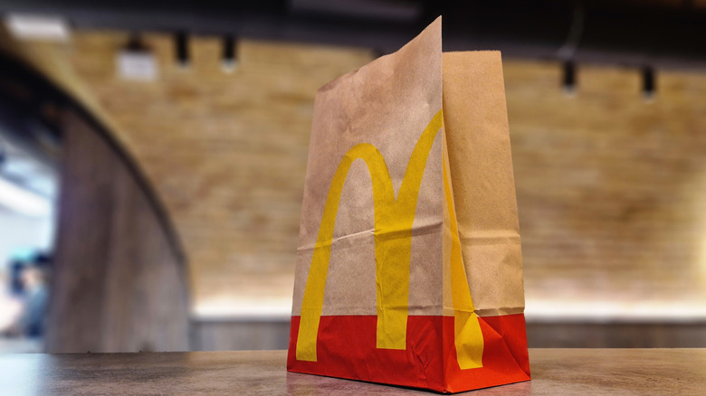 A paper carry-out bag from McDonald's rests on a solid surface