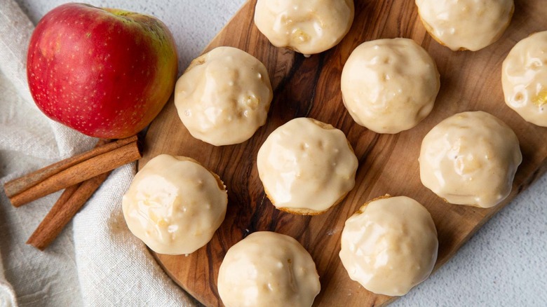 Glazed apple fritters on wooden board