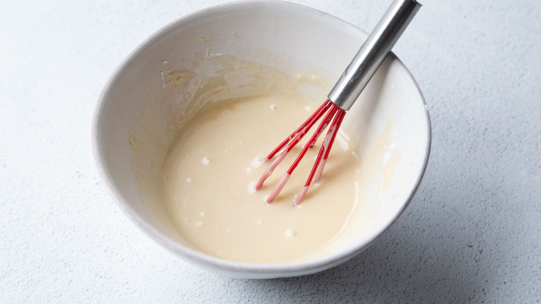 Sugar glaze in bowl with small whisk