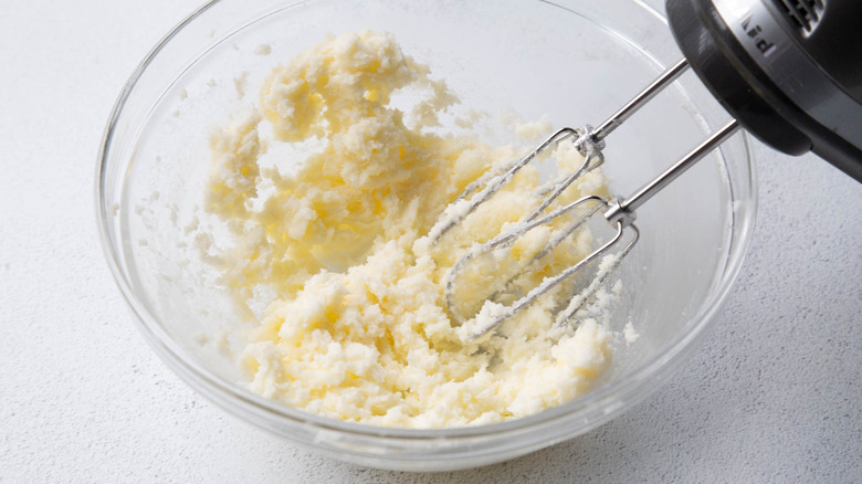 Butter and sugar mixed together in bowl with hand mixer