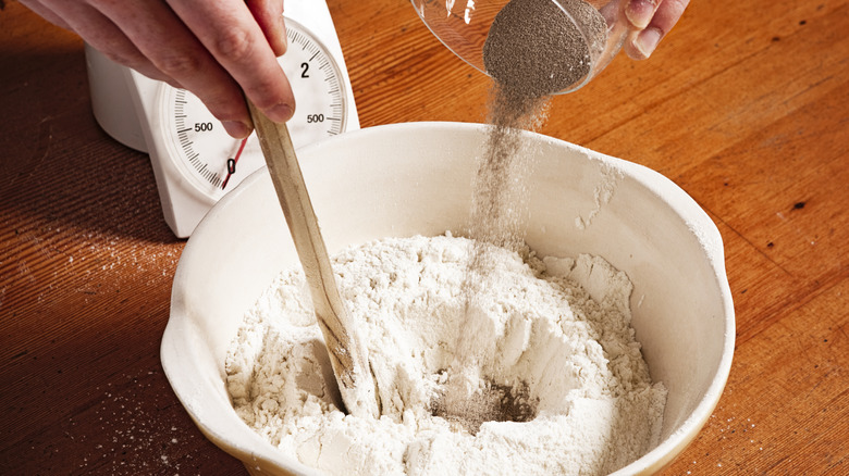 person pouring yeast in bowl