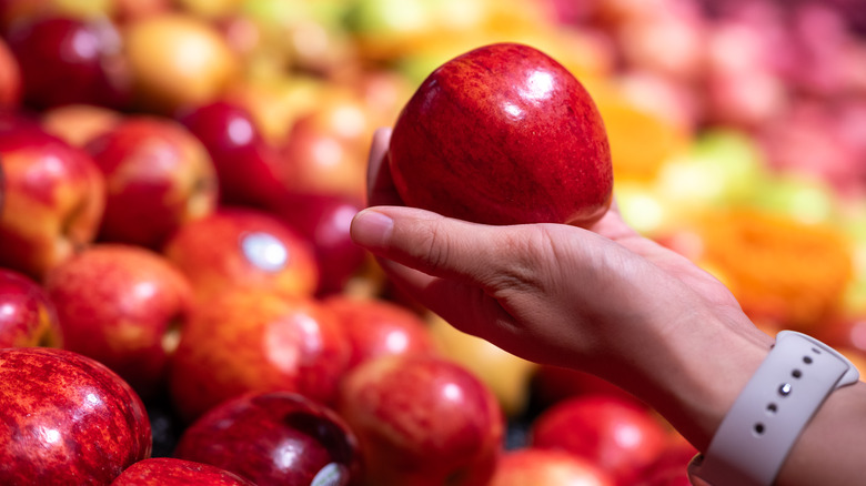 person holding shiny apple