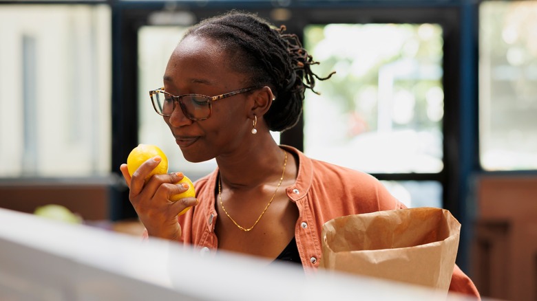 woman happily smelling lemons