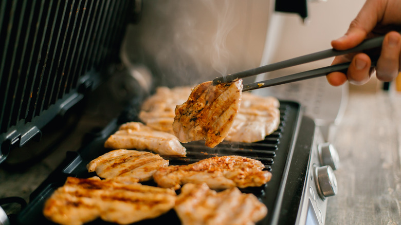 Flipping chicken on a grill