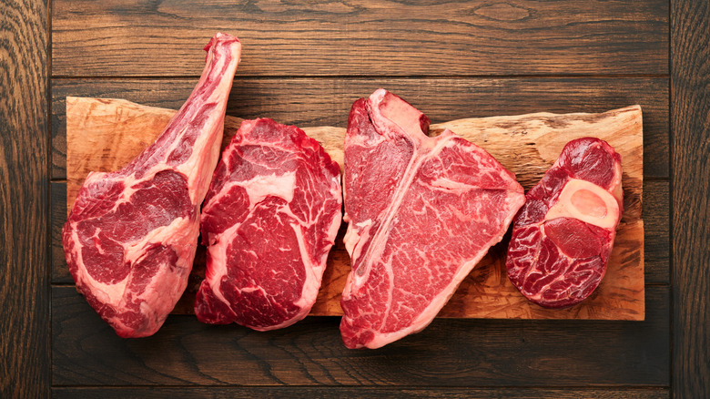 Raw steaks on a wooden board