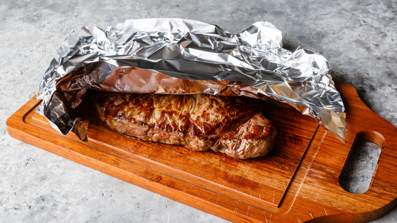 Grilled steak resting on a wooden board