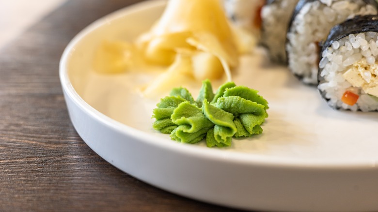 Close up of wasabi on a plate with sushi and ginger