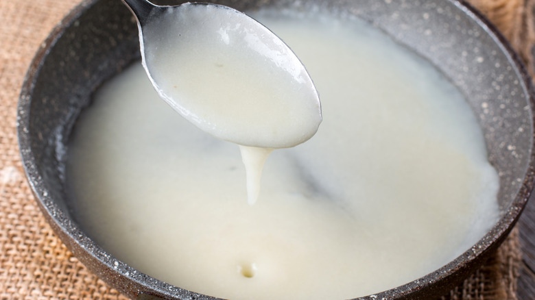 Bowl of roux dripping from spoon