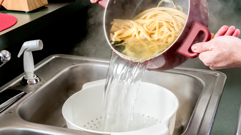 Person straining pasta water