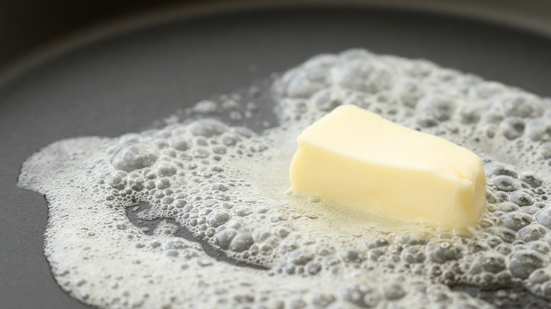 A pat of butter melting in a pan.