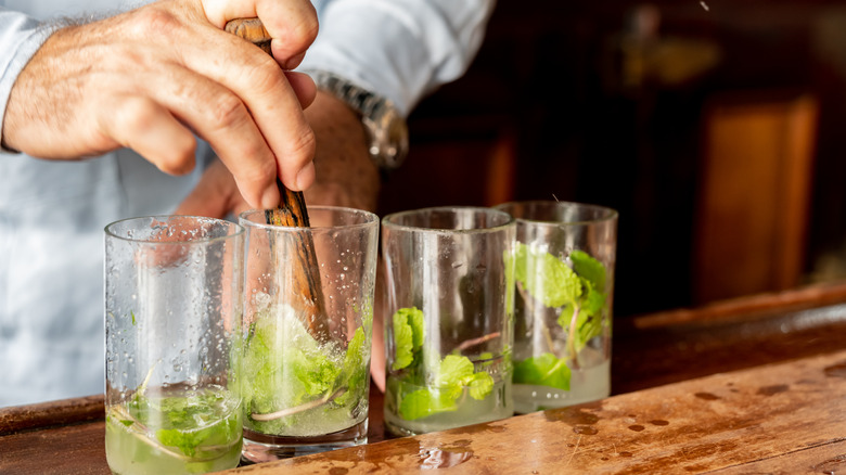 Bartender muddling mint