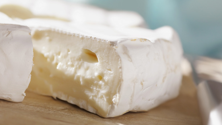 sliced brie cheese on cutting board