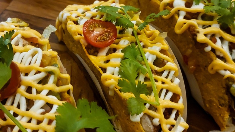 three tacos served with mustard