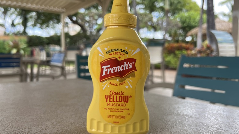 bottle of French's yellow mustard sitting on patio table