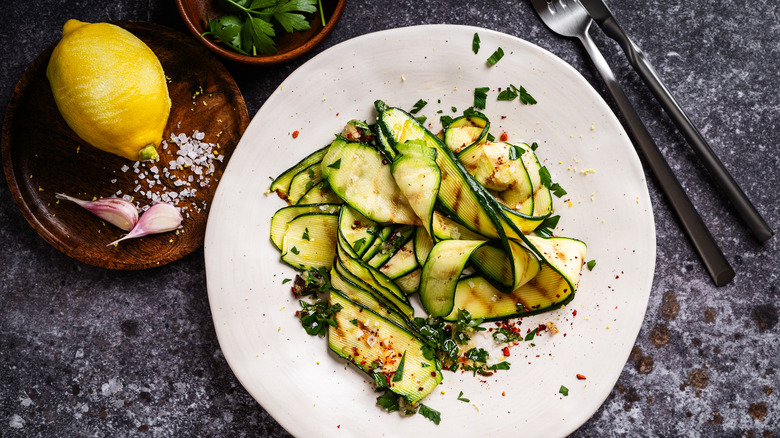 Thin slices of seasoned zucchini on white plate