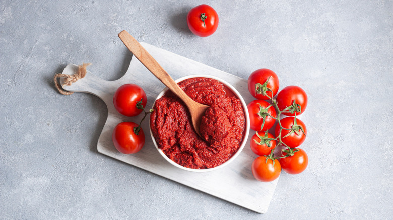 tomato paste in bowl on cutting board