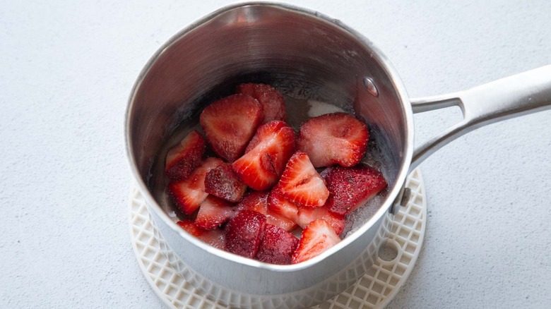 strawberries and sugar in a saucepan