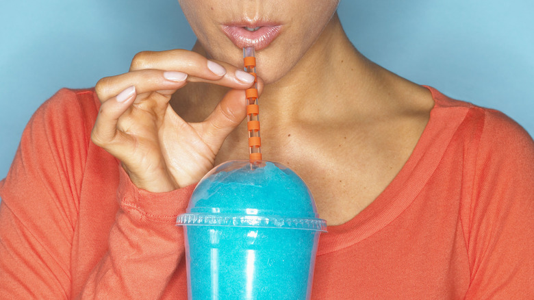 person drinking a slurpee