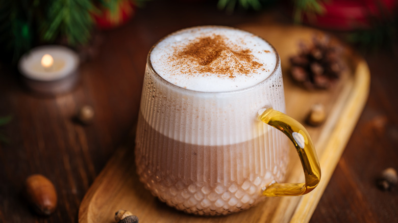 Glass mug of eggnog sprinkled with nutmeg in a festive Christmas atmosphere