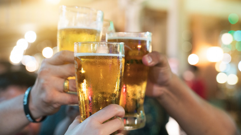 Hands toasting mugs of beer