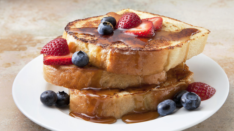 French toast topped with syrup and berries.