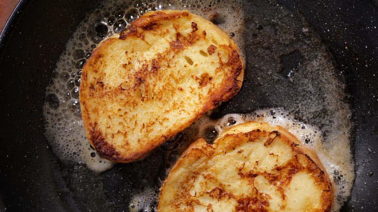 French toast frying in a cast iron skillet.