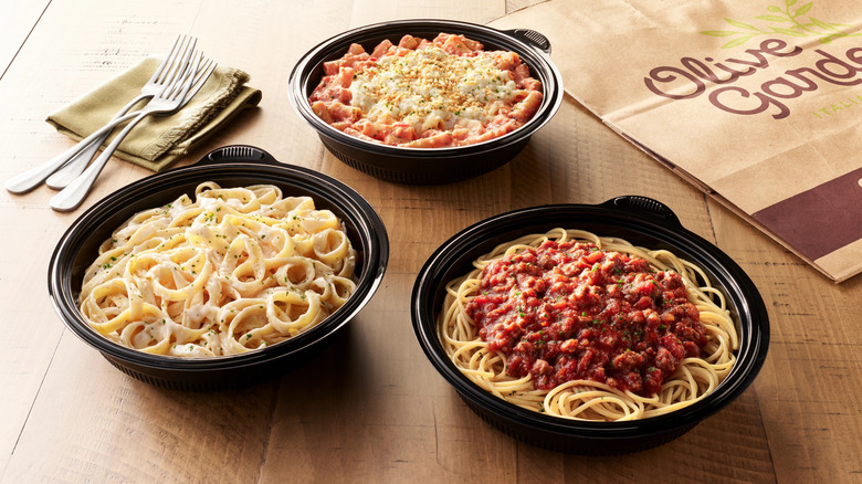 Olive Garden take-home pasta meals in black plastic bowls