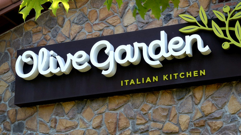 Olive Garden exterior sign on stone wall with green leaves