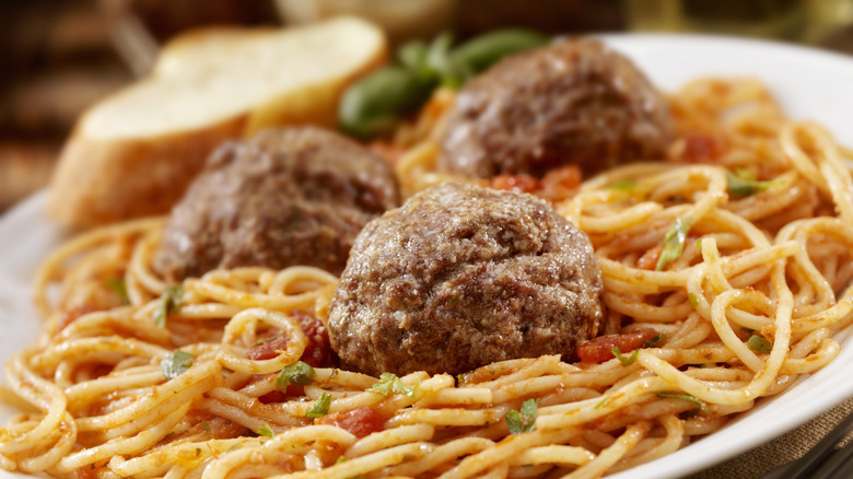 Closeup of spaghetti and meatballs with slice of bread