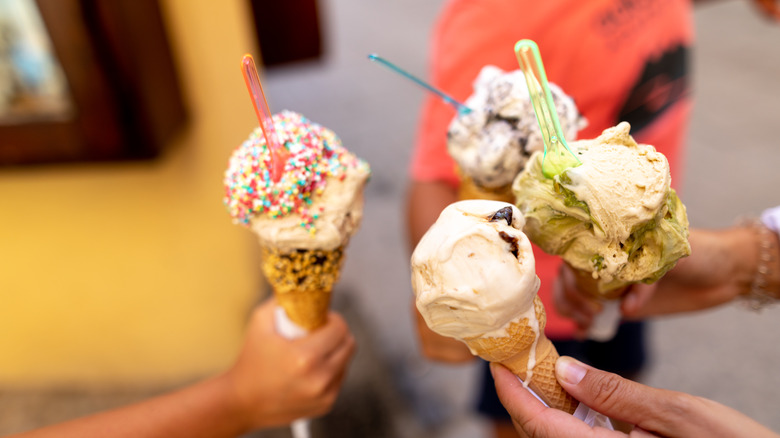 hands holding melting ice cream cones