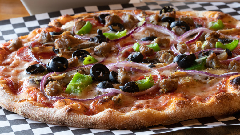 California style pizza topped with olives, onions, and peppers