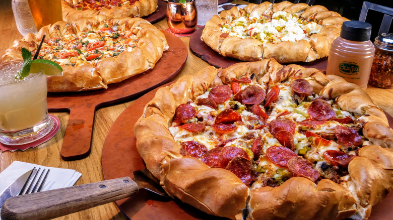 Colorado style pizza with pepperoni in front of two other pizzas