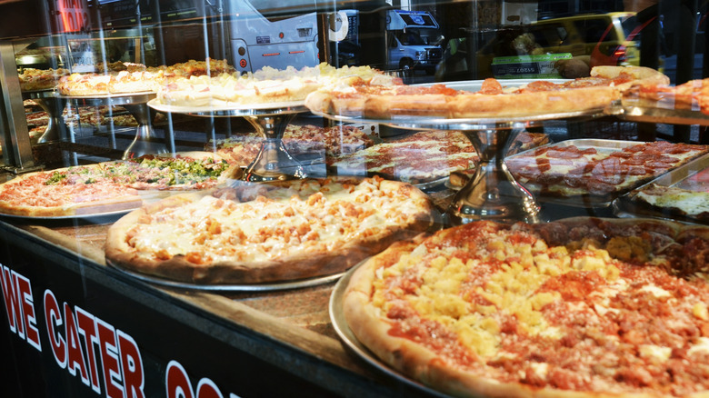 Assorted pizzas on display in a window