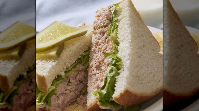 Ham salad sandwich on white bread with pickle slice