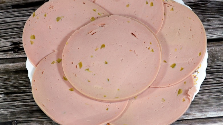 Slices of olive loaf luncheon meat stacked on plate