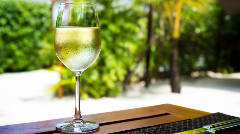 Glass of white wine on table with condensation on glass