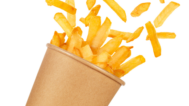 Fries spilling out of a to go drink cup