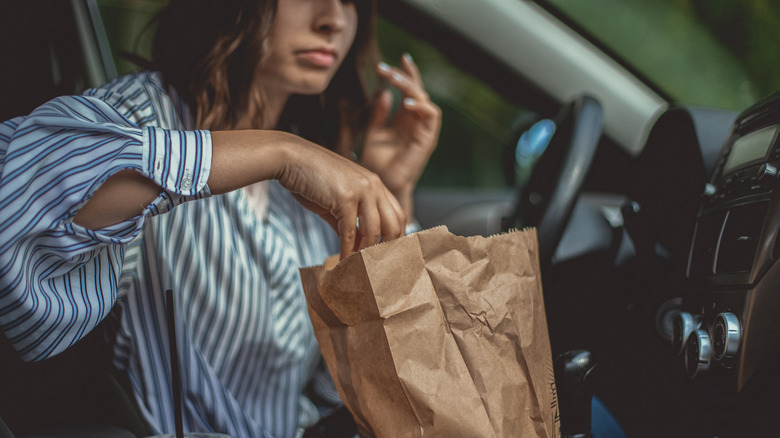 Woman eating fries in her car