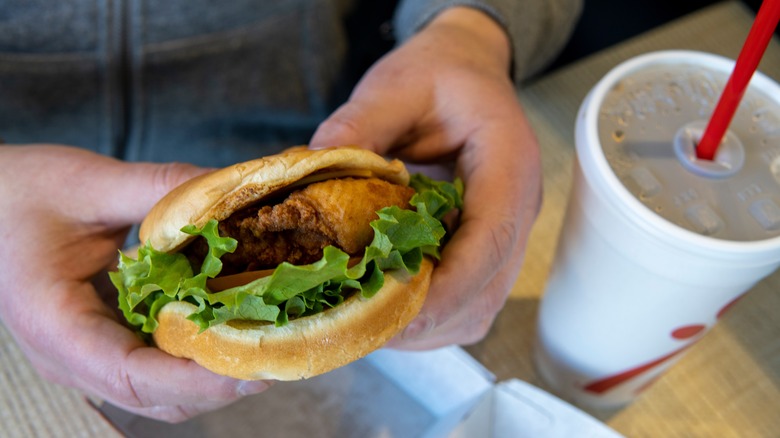 Hands holding a Chick-fil-A chicken sandwich