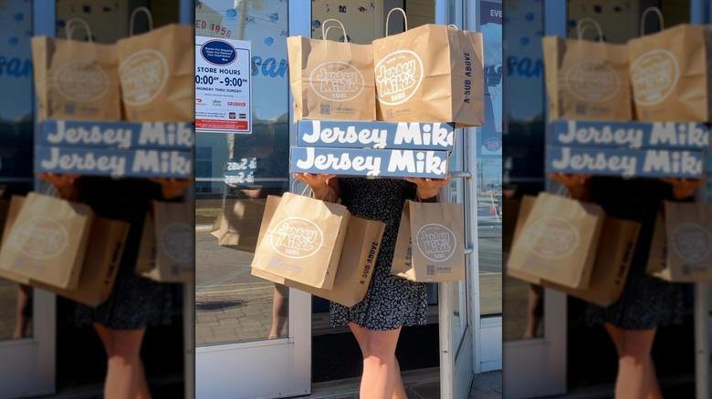 Person carrying Jersey Mike's bags