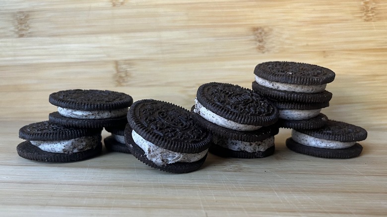 A pile of Loaded Oreo cookies sits on a wooden cutting board.