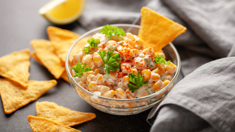 Eloté-style corn in a bowl with tortilla chips