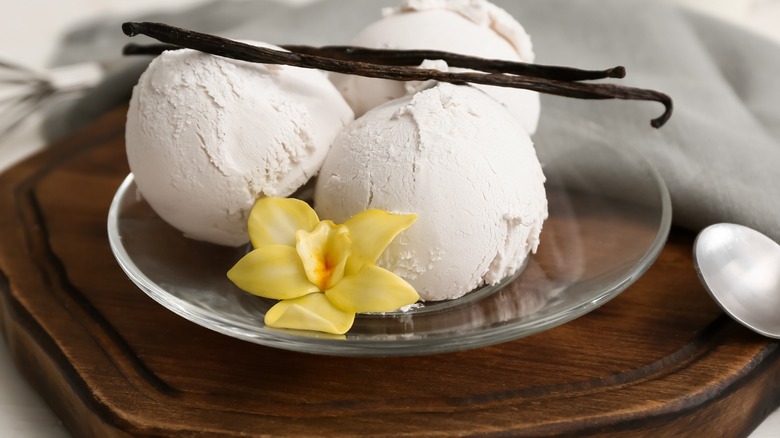 A bowl of three scoops of vanilla ice cream.