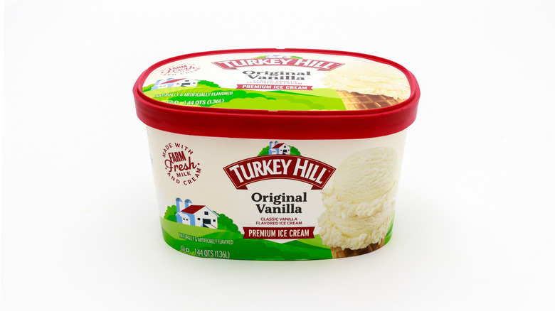 A tub of Turkey Hill premium vanilla ice cream on a white background